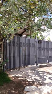 a black fence with a tree in front of it at Microcasa Pousada Residencial Botânica com Kit Café da manhã in Itupeva