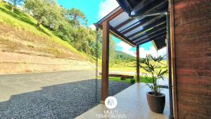 a glass door of a building with a potted plant at Casa Completa | 2 Suítes + Jardim com Fogo de Chão in Urubici +83 photos