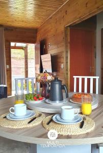 a table with a tea kettle on top of it at Casa Completa | 2 Suítes + Jardim com Fogo de Chão in Urubici