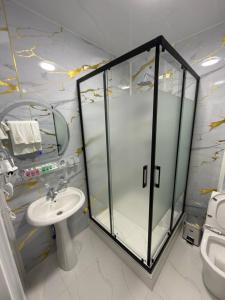 a bathroom with a glass shower and a sink at The Avenue Hotel in Kogon +14 photos