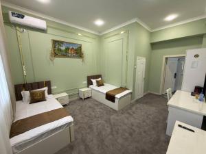 a small room with two beds and a bathroom at The Avenue Hotel in Kogon
