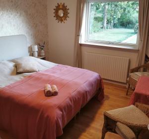 a bedroom with a bed with a pair of shoes on it at TheGilgahouse Gardenroom in Nakskov