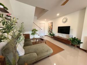 a living room with a couch and a flat screen tv at Nong Hoi Nest, New Townhome with Positive Pressure Air Purifier in Chiang Mai