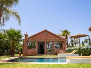 a house with a swimming pool in front of a house at SUMAHAN SUITES & SPA in Marrakesh