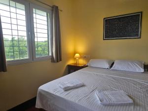 a bedroom with a bed with two towels on it at Surya Villa Guesthouse in Auroville
