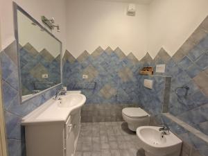 a bathroom with two sinks and a toilet and a mirror at Da Ghjuannedda in Arzachena