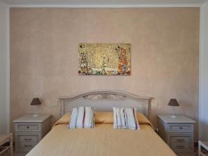 a bedroom with a bed with two night stands and a painting at Da Ghjuannedda in Arzachena +9 photos
