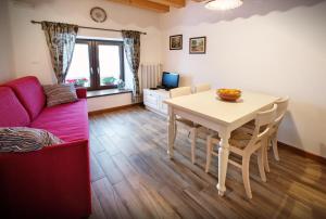 a living room with a table and a red couch at Albergo Diffuso Tolmezzo in Tolmezzo