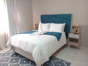 a bedroom with a large bed with a blue headboard at Joyful Home Bela-Bela in Bela-Bela