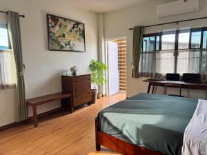 a bedroom with a bed and a desk and window at Nong Hoi Nest, New Townhome with Positive Pressure Air Purifier in Chiang Mai