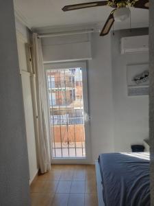 a bedroom with a bed and a large window at Bungalow Monover Playa in Santa Pola