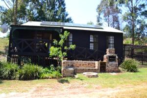 a small black house with a solar roof at Trout Ways in Waterval Boven