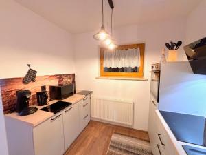 a kitchen with white cabinets and a microwave at Apartment Vallis Bella by Interhome in Langesthei +20 photos