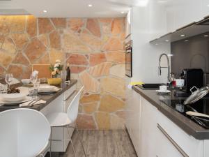 a kitchen with a counter and a stone wall at Apartment Stem 2 by Interhome in Verbier +17 photos
