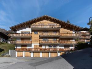 an apartment building with wooden balconies and a parking lot at Apartment Stem 2 by Interhome in Verbier