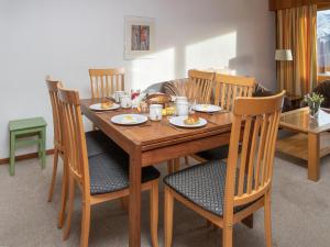 a wooden dining room table with chairs and food on it at Apartment Porthos 37 by Interhome in Verbier