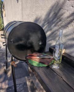 a grill with a bottle of wine and a glass at Casita Tafí del Valle in Tafí del Valle