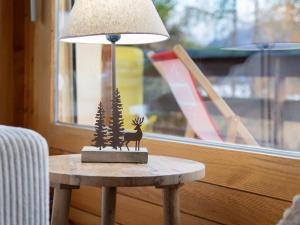 a lamp sitting on a table next to a window at Apartment Beau Site No 21 by Interhome in Ovronnaz