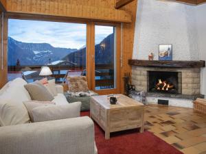 a living room with a fireplace with a mountain view at Apartment Beau Site No 21 by Interhome in Ovronnaz