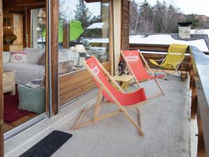 two chairs sitting on the porch of a house at Apartment Beau Site No 21 by Interhome in Ovronnaz