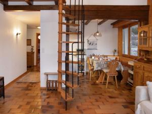 a kitchen and dining room with a wooden spiral staircase at Apartment Beau Site No 21 by Interhome in Ovronnaz +19 photos