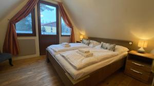 a bedroom with a large bed with two towels on it at Chalet Green Park in Stará Lesná
