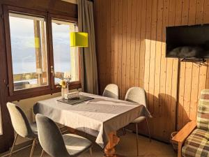 a dining room with a table and chairs and a window at Apartment Platten by Interhome in Gersau