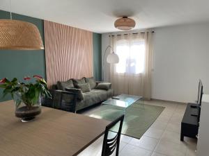 a living room with a couch and a table at appartement cosy in Nîmes +2 photos