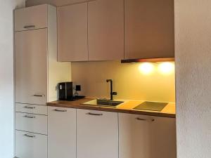 a kitchen with white cabinets and a sink at Apartment Platten by Interhome in Gersau
