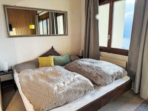 a bed with two blankets on it with a window at Apartment Platten by Interhome in Gersau