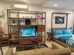 a living room with a bed and a flat screen tv at Timurbay Seafront By Moonlight Sea & Poolview in Kuantan