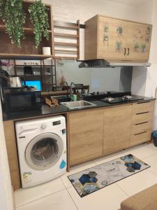 a kitchen with a washing machine and a sink at Timurbay Seafront By Moonlight Sea & Poolview in Kuantan