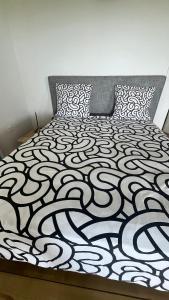 a bedroom with a bed with a black and white comforter at Lakay zot in Le Vauclin