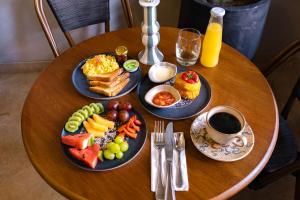 a wooden table with plates of breakfast food on it at Hotel Casa Bianca by Faranda Boutique in Cartagena de Indias