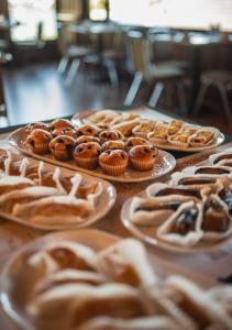 a table topped with plates of pastries and cupcakes at Villa del Rio Express in Valdivia