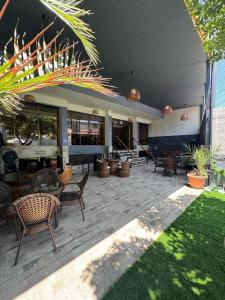 a patio with chairs and tables in a building at Hotel Garden Latorre in Iquique
