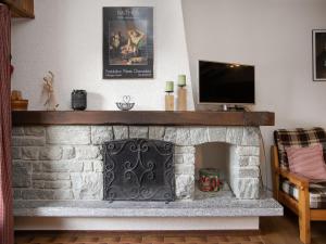 a living room with a stone fireplace with a flat screen tv at Apartment Parc B 431 by Interhome in Champex