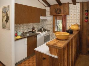 a kitchen with wooden cabinets and a bowl on a counter at Apartment Parc B 431 by Interhome in Champex +33 photos