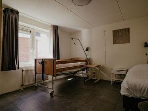a room with a bed and a piano in it at Holiday Home Kraaijennest by Interhome in Uitgeest