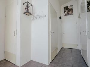 a hallway with white walls and two doors at Holiday Home Kraaijennest by Interhome in Uitgeest