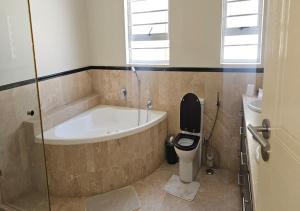 a bathroom with a tub and a toilet and a sink at The White House at Plattekloof in Plattekloof +42 photos