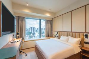 a hotel room with a bed and a large window at Weave Suites - Hillside in Singapore +57 photos