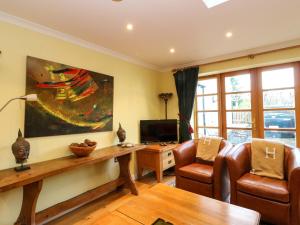 a living room with a table and chairs and a tv at 78 Findhorn in Forres