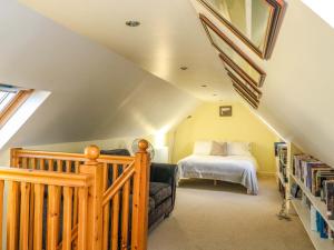 a attic bedroom with a bed and a book shelf at 78 Findhorn in Forres
