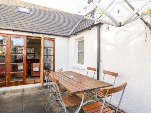 a wooden table and chairs in front of a house at 78 Findhorn in Forres