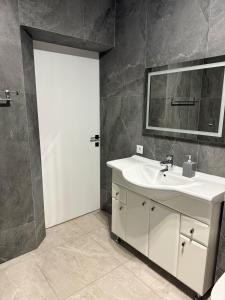 a bathroom with a white sink and a mirror at Yaremche Soul House in Yaremche