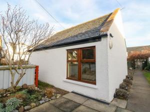 a white house with a window in a yard at 78 Findhorn in Forres