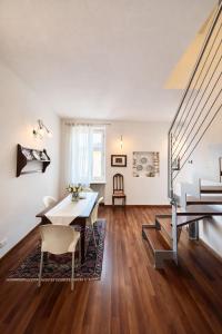 a living room with a table and chairs and stairs at La Suite del Centro in Lazise