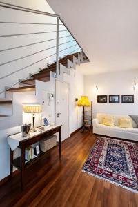 a living room with a white couch and stairs at La Suite del Centro in Lazise