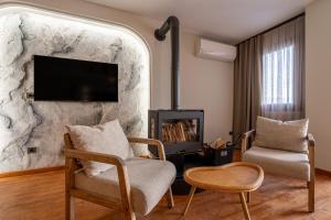 a living room with two chairs and a fireplace at Ephesus Select Suites in Kuşadası